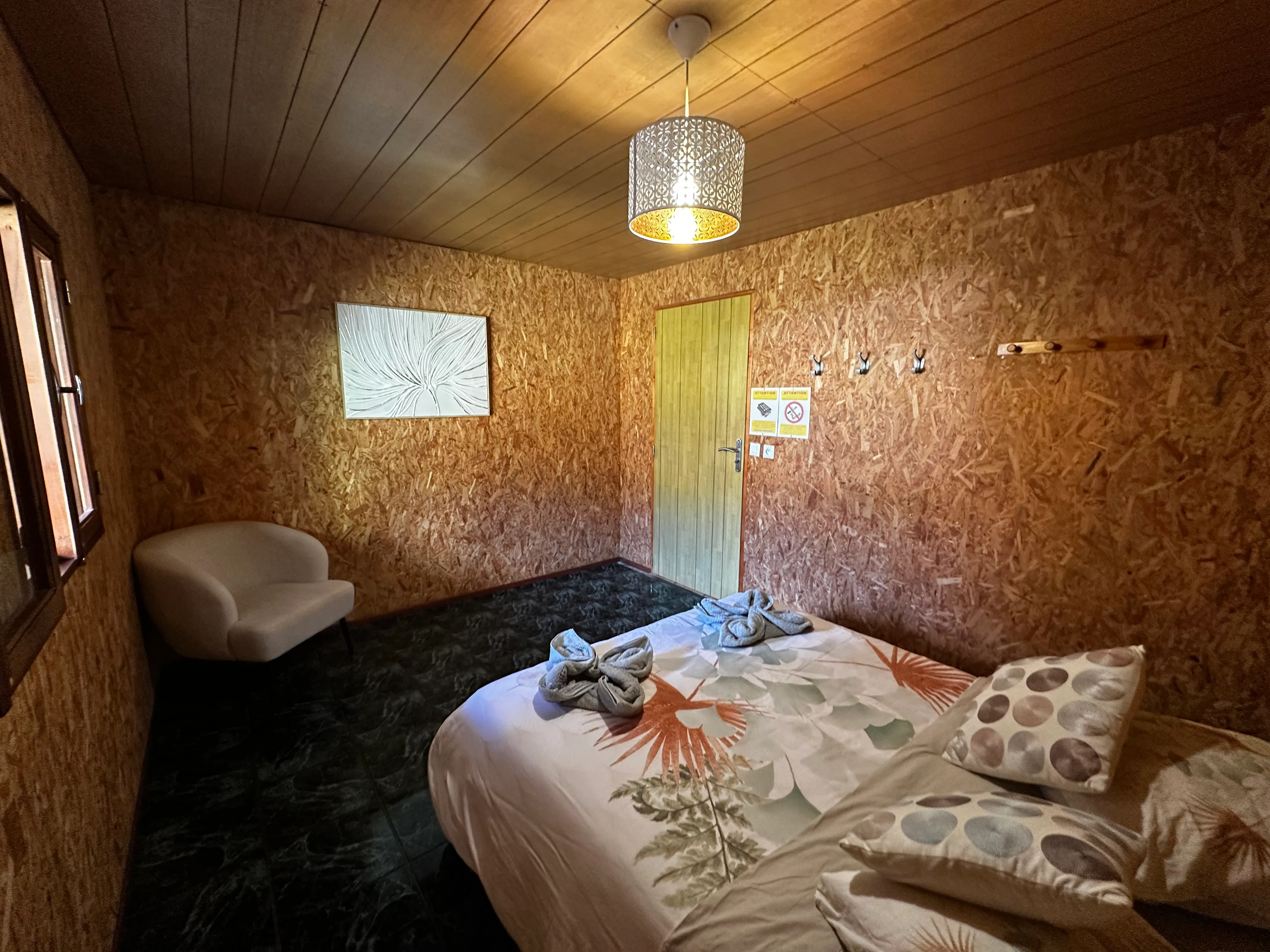 Chambre double n°2 du gîte : lit double, parois en bois, décoration sobre