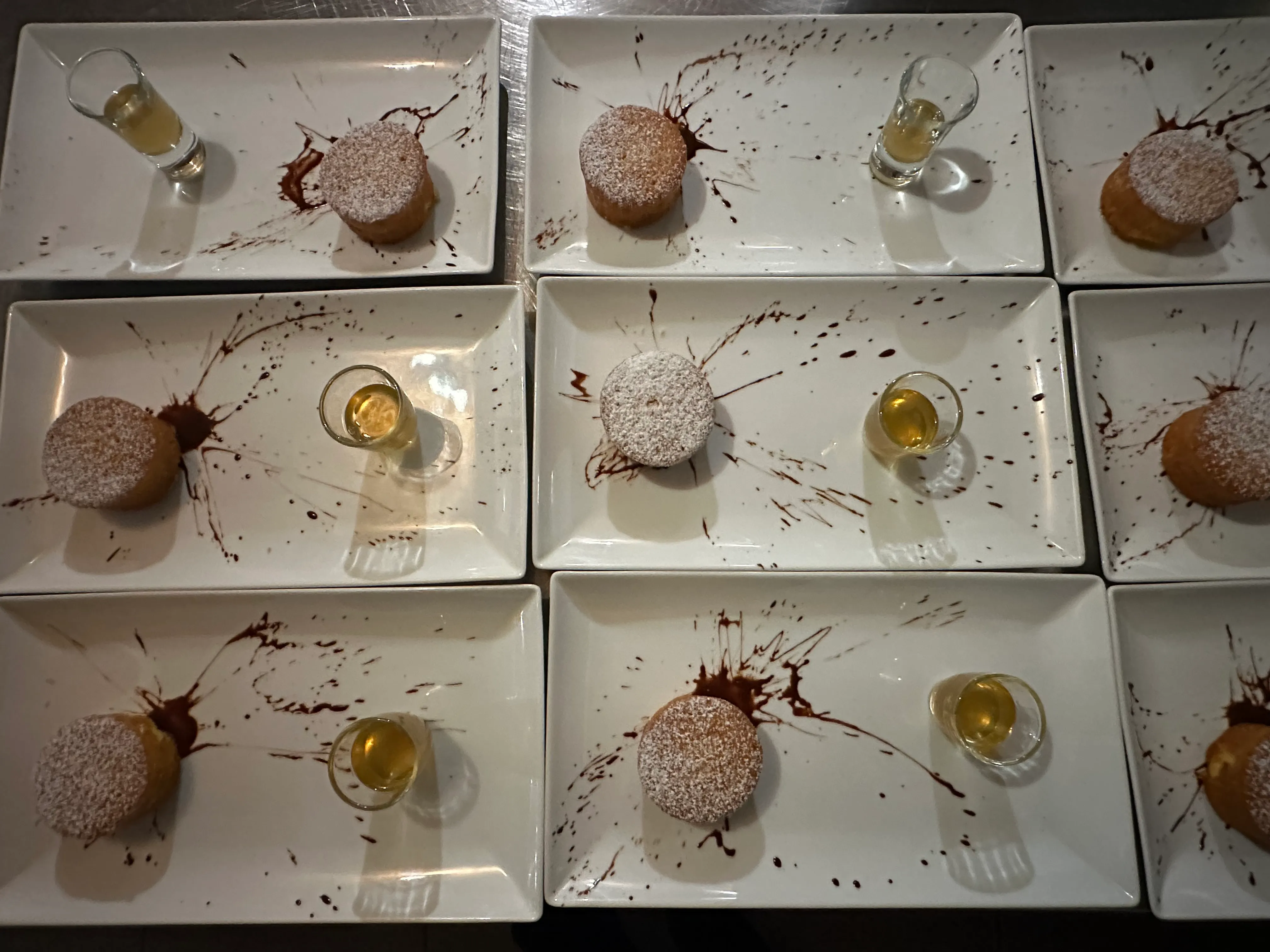 Desserts dressés à l'assiette : gâteaux au sucre glace, traits de chocolat et petit verre en accompagnement